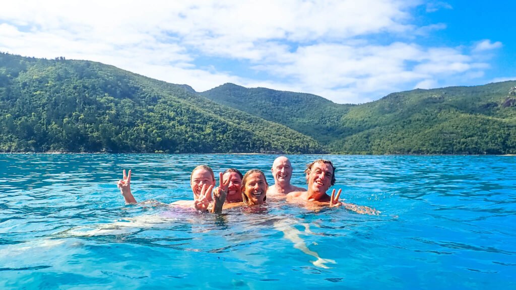 A group of friends hanging out in the water after completing an ocean swim